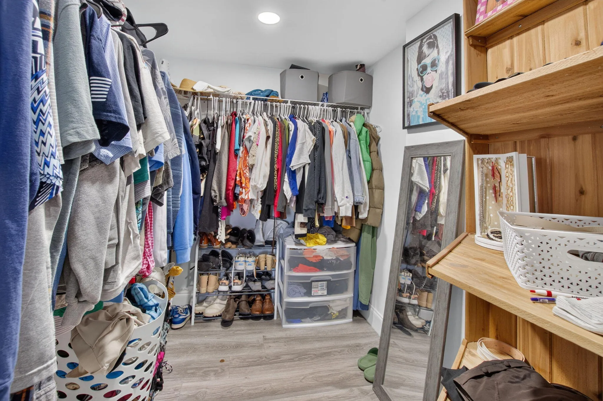 Walk-in closet featuring built-in shelving, wood-finish flooring, and recessed lighting