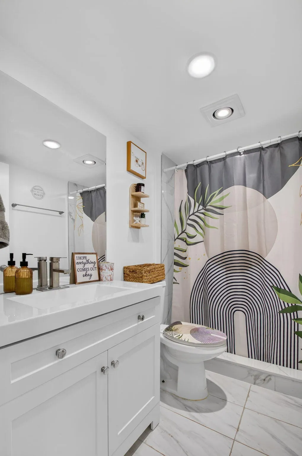 Bathroom featuring a white vanity with integrated sink, chrome faucet, and white shaker-style cabinetry