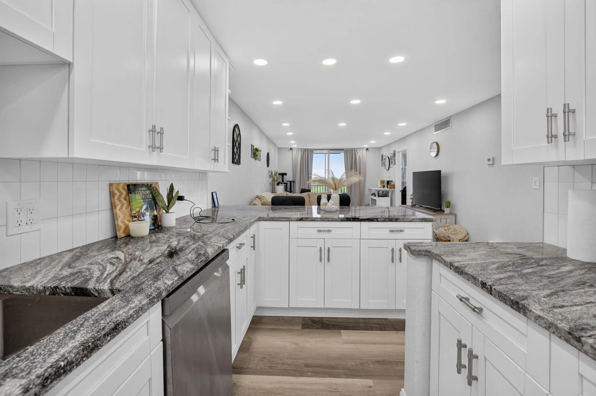 Contemporary kitchen featuring white cabinetry and dark patterned countertops
