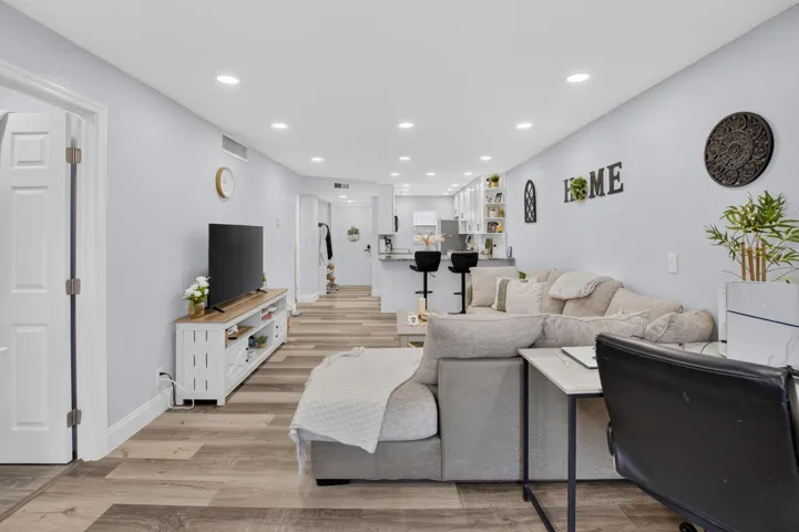 Bright living space featuring Vinyl wood-finish flooring, recessed lighting, and a light gray wall color