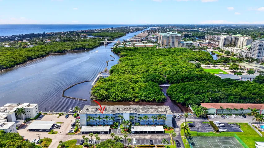Waterfront building with direct ocean access, featuring a tennis court and parking facilities