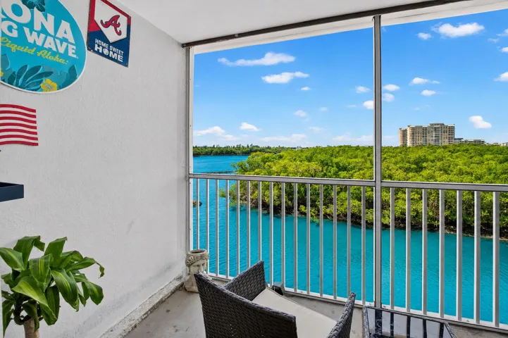 Balcony with water frontage featuring a railing system and screening