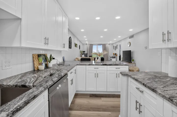 Contemporary kitchen featuring white cabinetry and dark patterned countertops