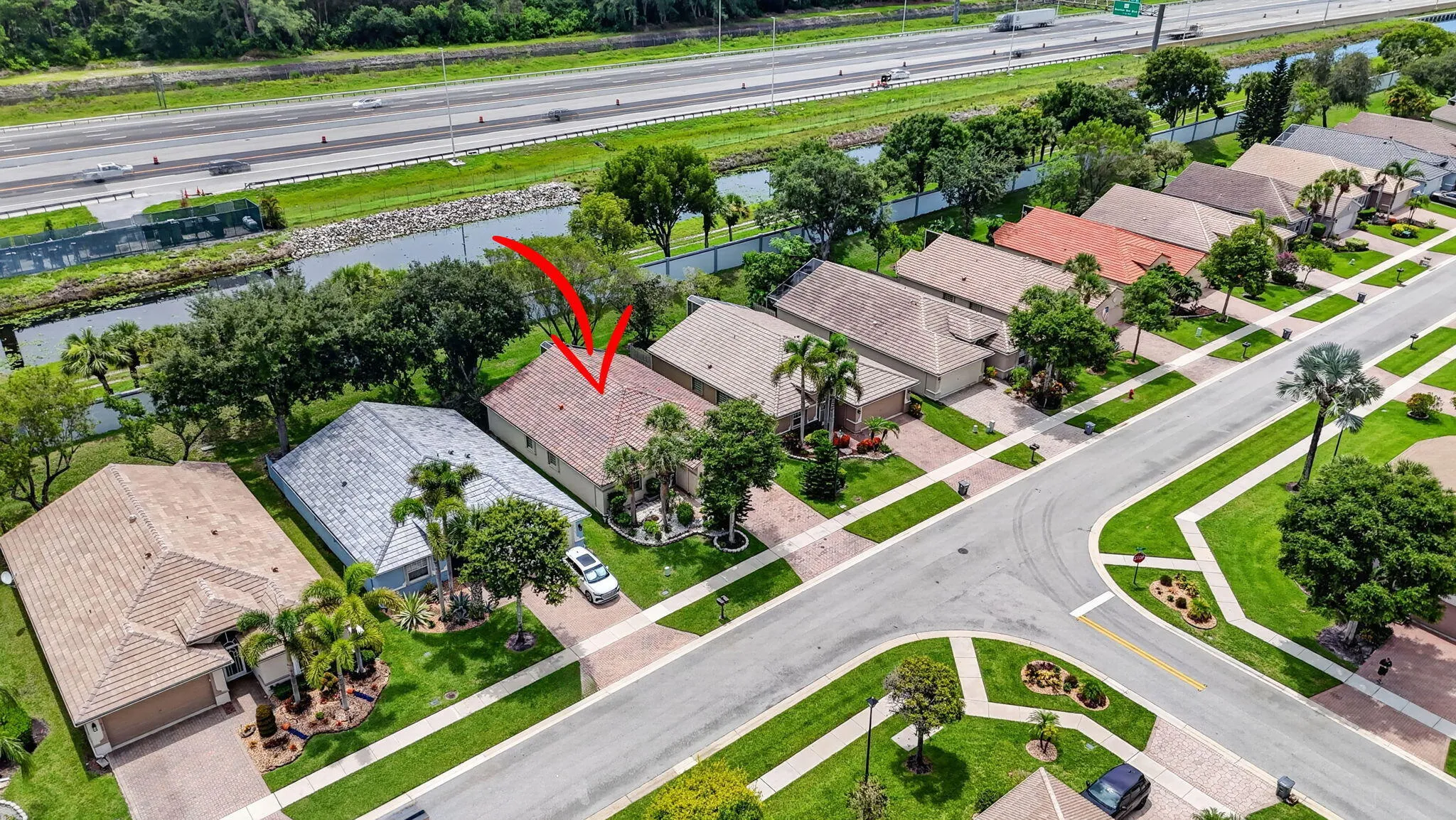 Tile roof residence featuring a concrete driveway, established landscaping, and a fenced perimeter