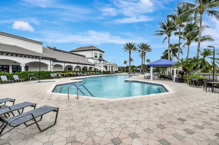 Expansive outdoor pool with integrated spa, surrounded by a paver patio