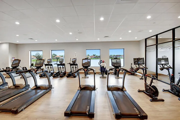 Fitness center featuring multiple treadmills, elliptical machines, and stationary bikes