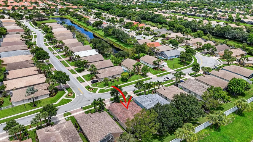 Aerial perspective of a residential neighborhood with verdant landscaping, established street networks, and a visible water feature