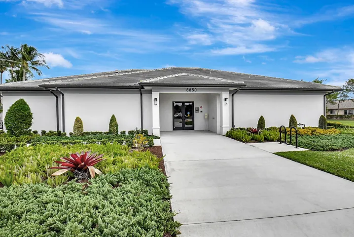 Contemporary single-story building featuring a tile roof and a white stucco exterior
