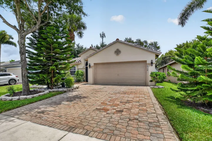 Stucco exterior with a tiled roof, featuring an integrated two-car garage