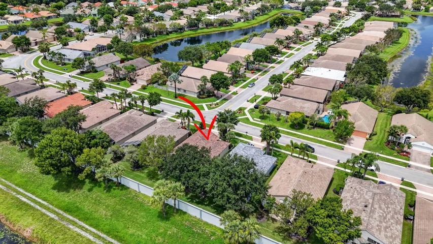 Aerial perspective of a residential neighborhood featuring a network of streets, waterways, and homes with varying roof styles