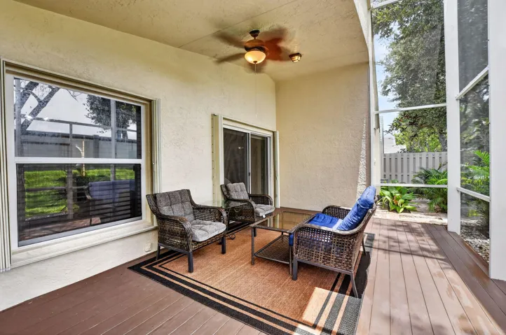 Screened patio featuring wood-finish flooring, a ceiling fan with integrated lighting, and direct access to interior spaces through a sliding glass door