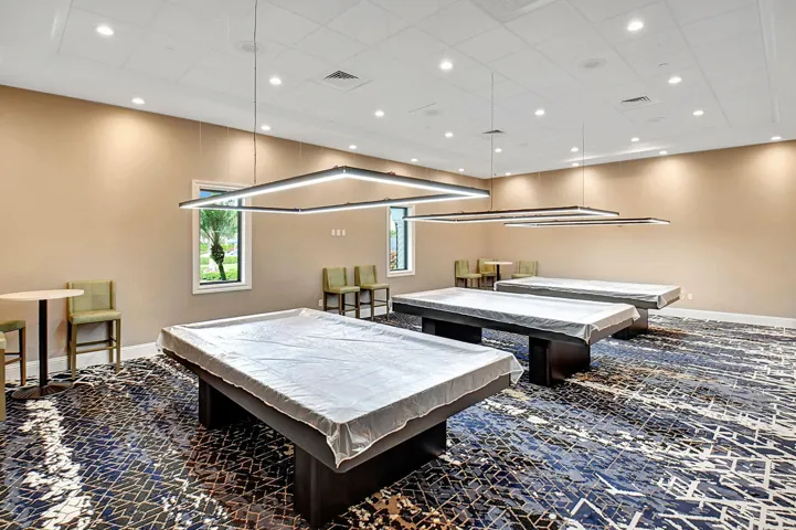 Recreational room featuring three billiard tables, contemporary pendant lighting, recessed ceiling lights, and patterned carpeting