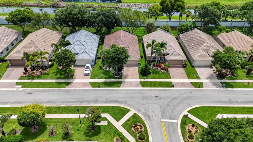 Aerial perspective showcasing multiple properties with uniform landscaping and tile roofs