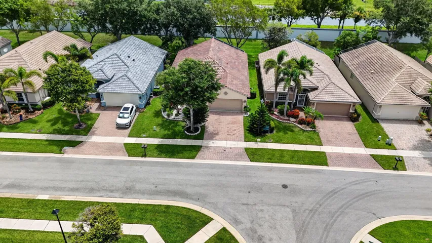 Residential street with brick paver driveways and meticulously maintained lawns