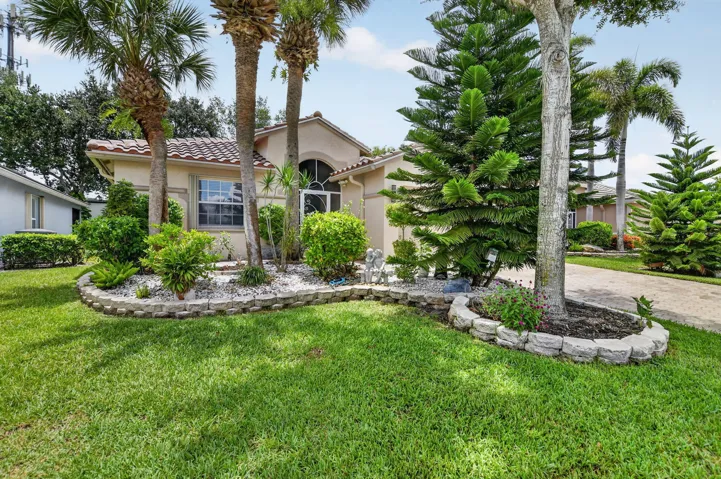 Mediterranean-style exterior featuring a tile roof, arched entryway, and multiple windows