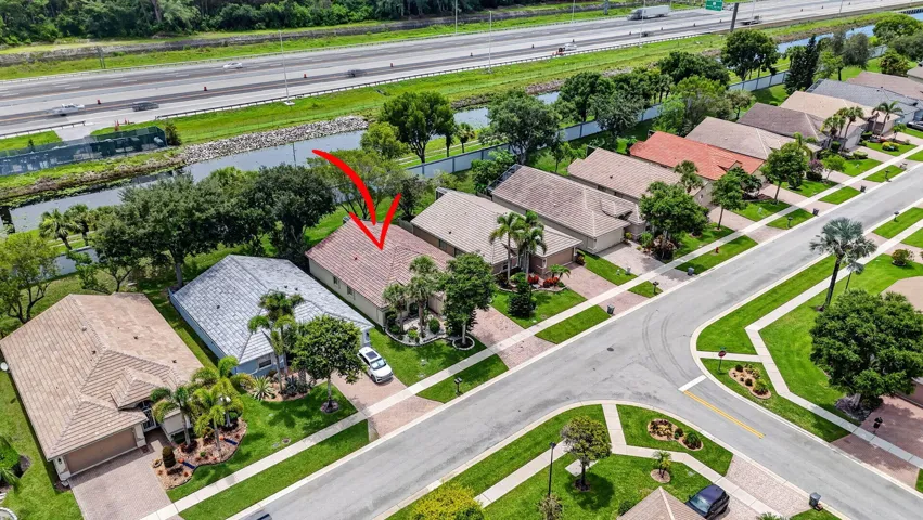 Tile roof residence featuring a concrete driveway, established landscaping, and a fenced perimeter