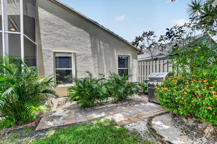 Outdoor patio area featuring paver stones and a privacy fence