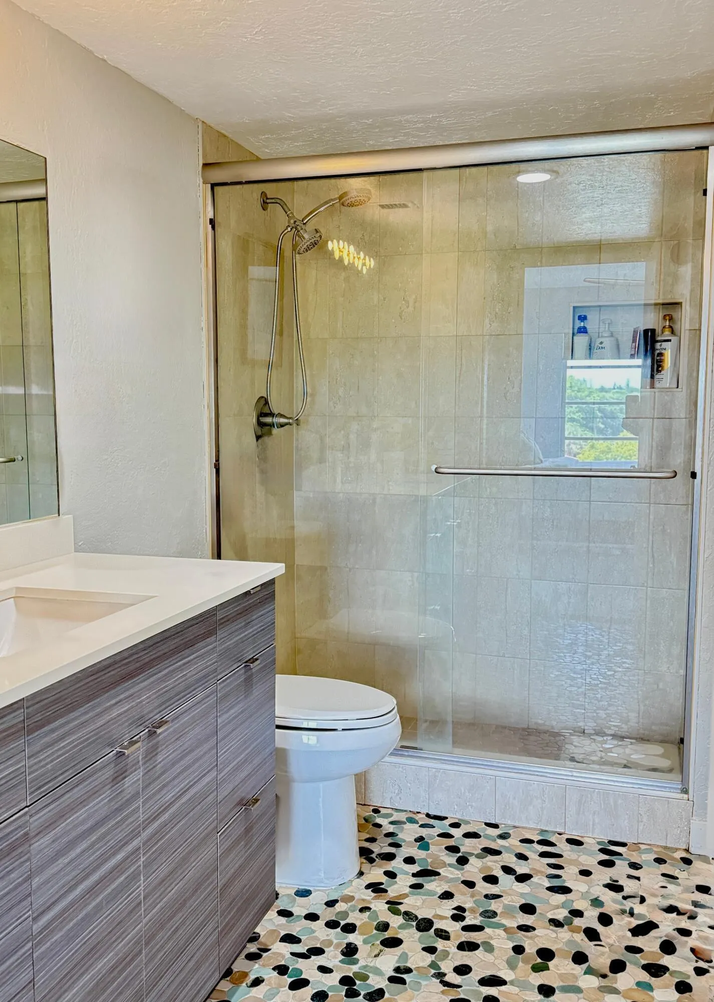 Bathroom remodel with river rock floors, walk-in shower basin and new vanity