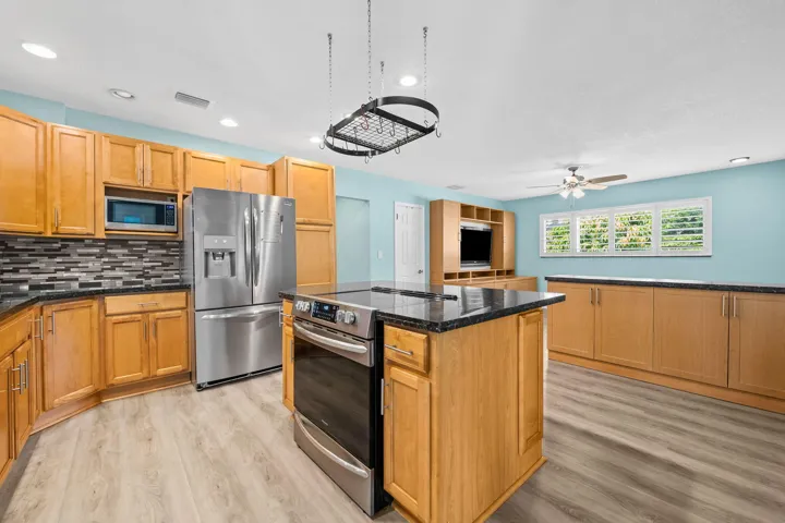Open kitchen with cook island and french door refrigerator, pantries