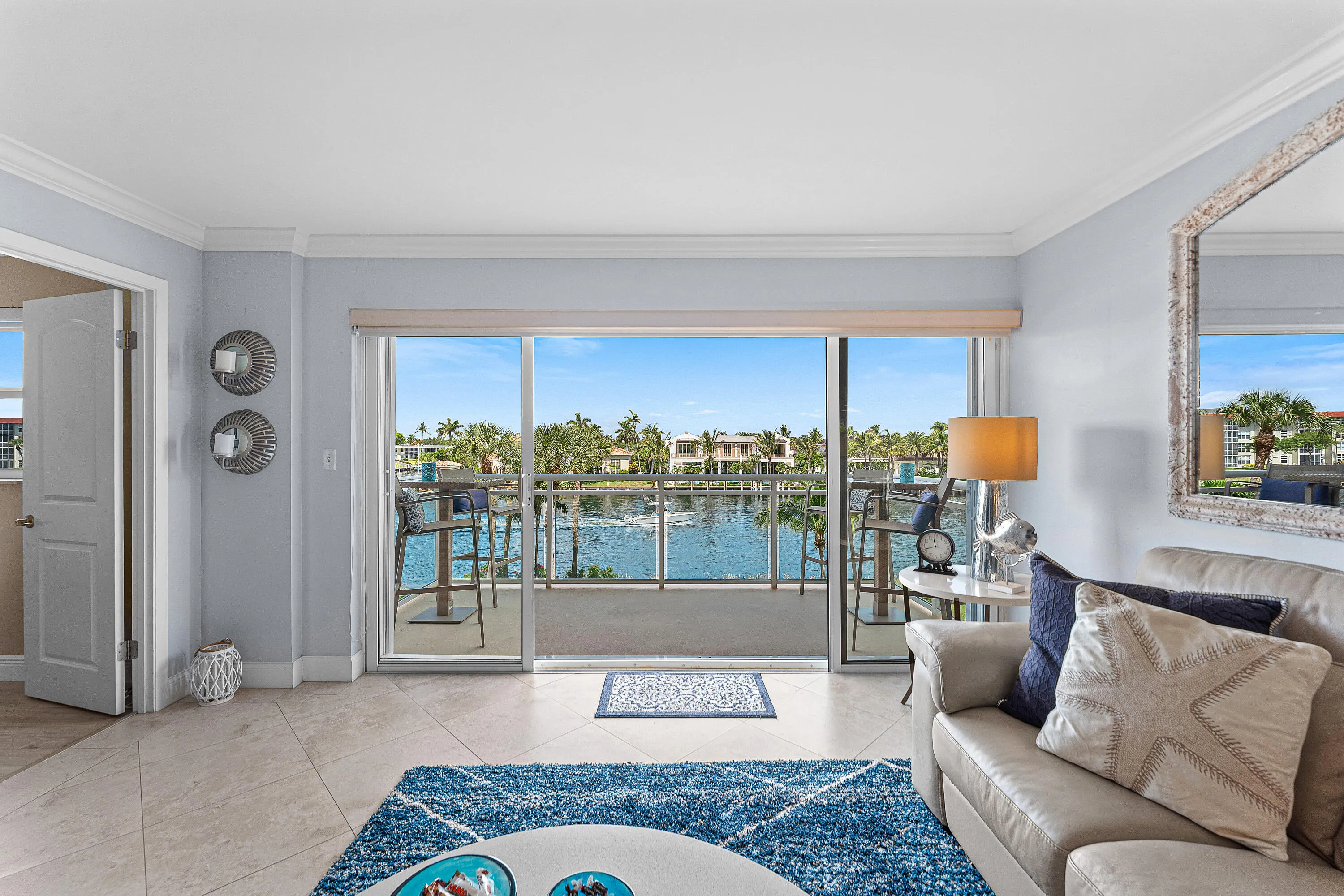 Spacious living area featuring large sliding glass doors opening to a balcony with waterway access