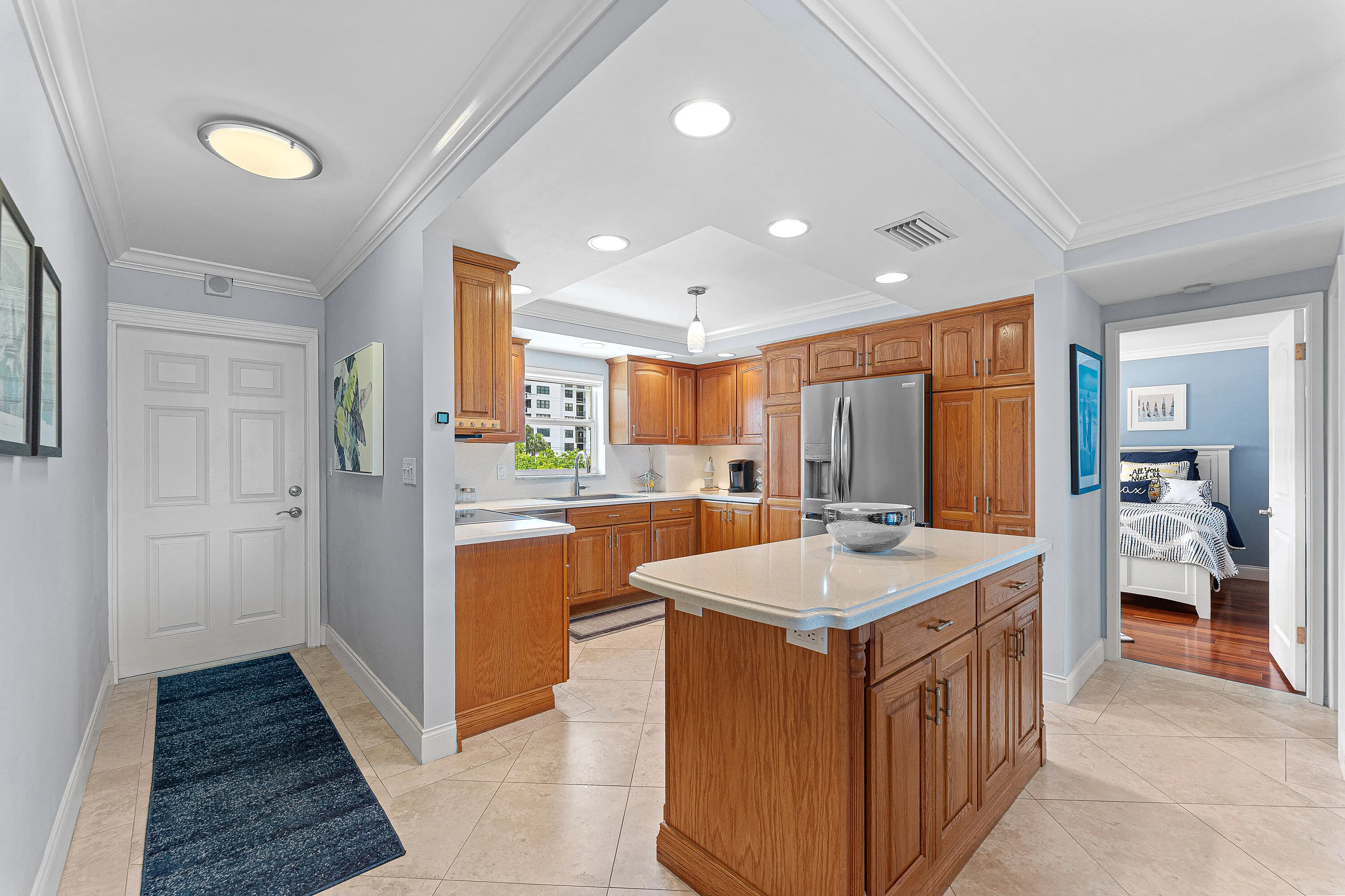 Kitchen featuring wood cabinetry, stainless steel appliances, and a central island with a white countertop