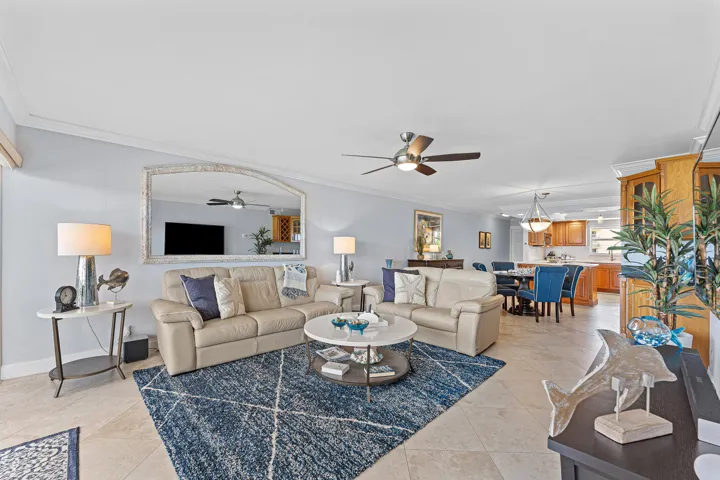 Spacious living area featuring light-toned flooring and crown molding