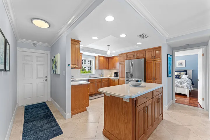 Kitchen featuring wood cabinetry, stainless steel appliances, and a central island with a white countertop