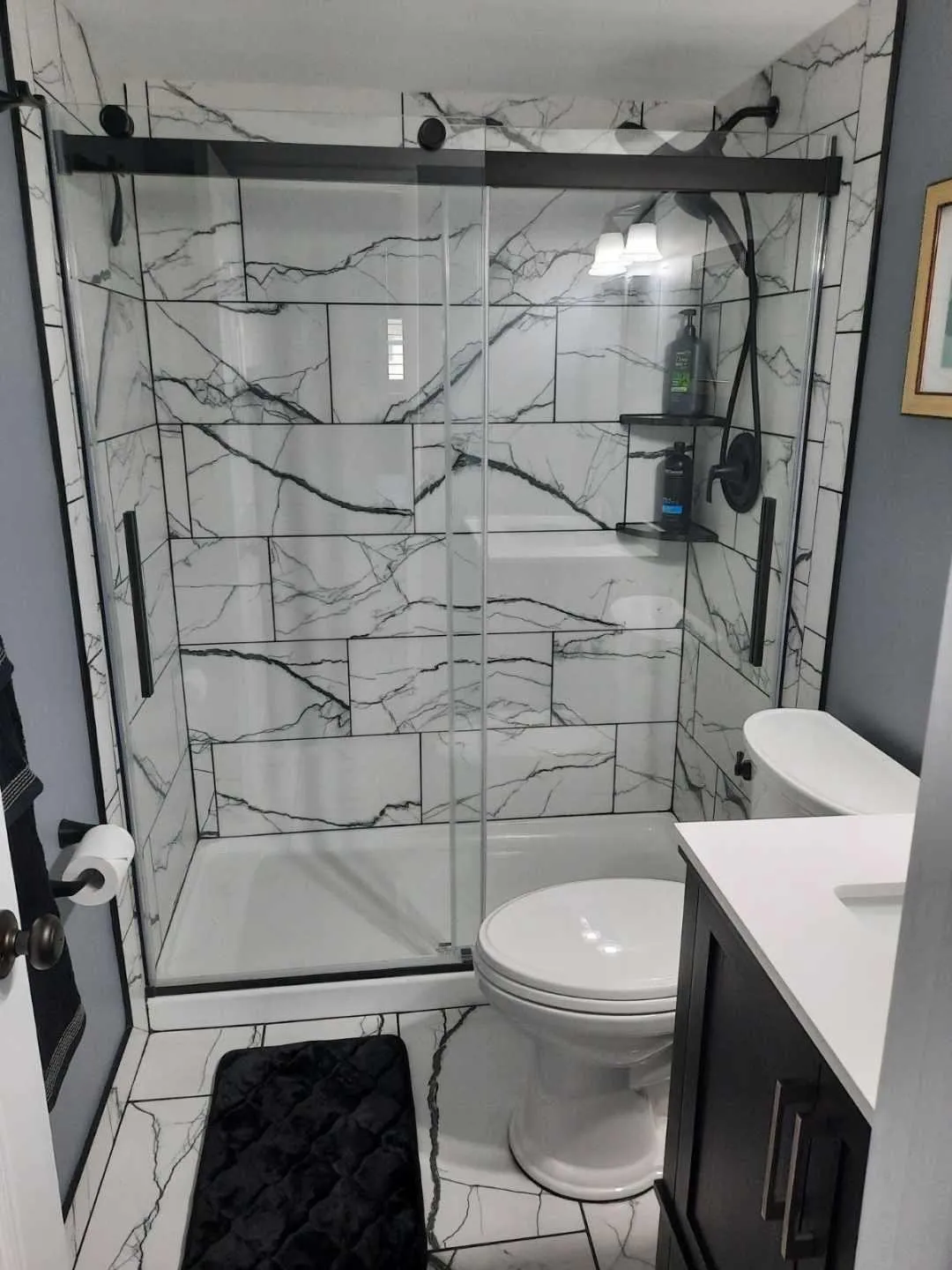 Shower with frameless glass enclosure and black hardware