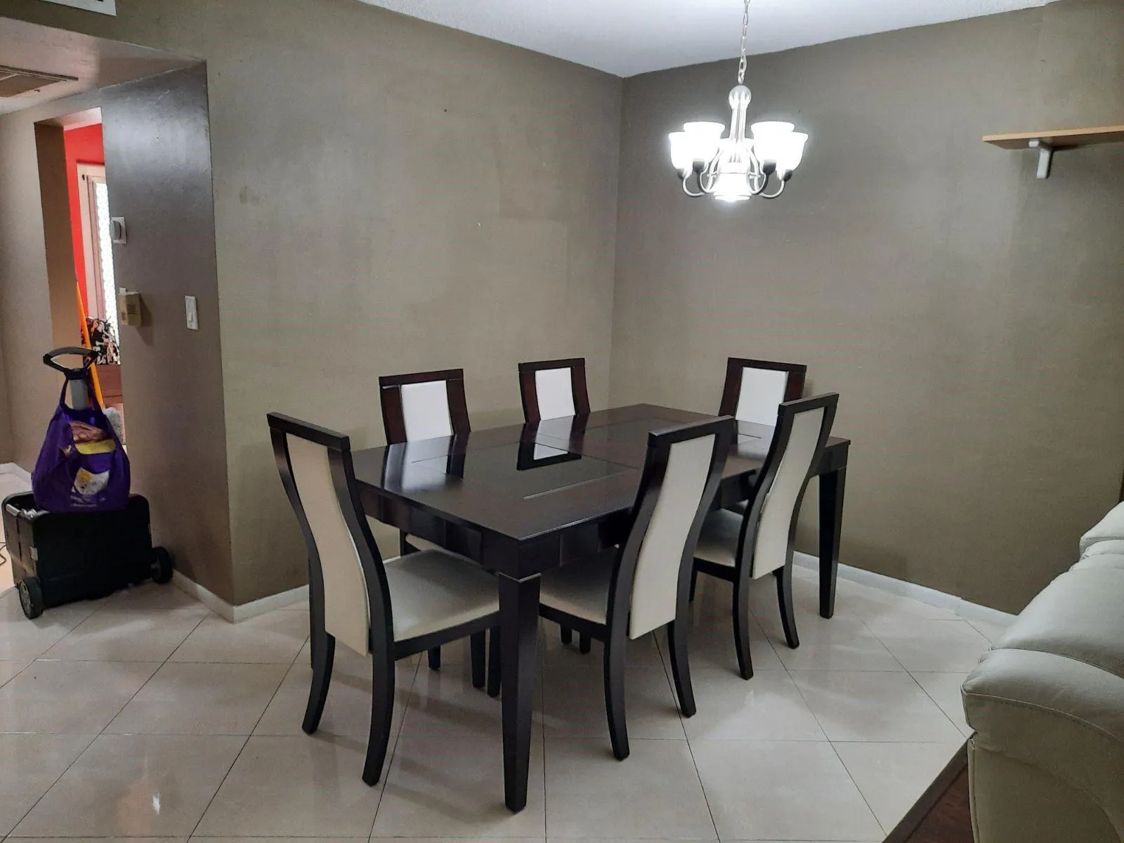 Dining area featuring neutral wall tones and a contemporary chandelier