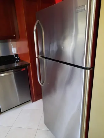 Stainless steel refrigerator featuring a top freezer and dual handles
