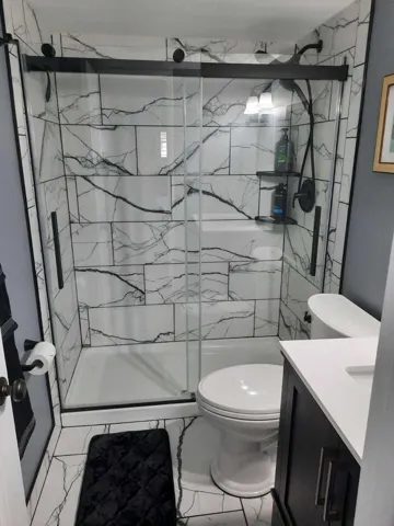 Shower with frameless glass enclosure and black hardware