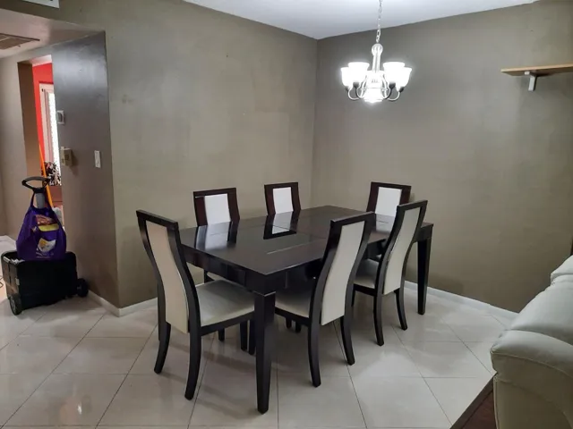 Dining area featuring neutral wall tones and a contemporary chandelier