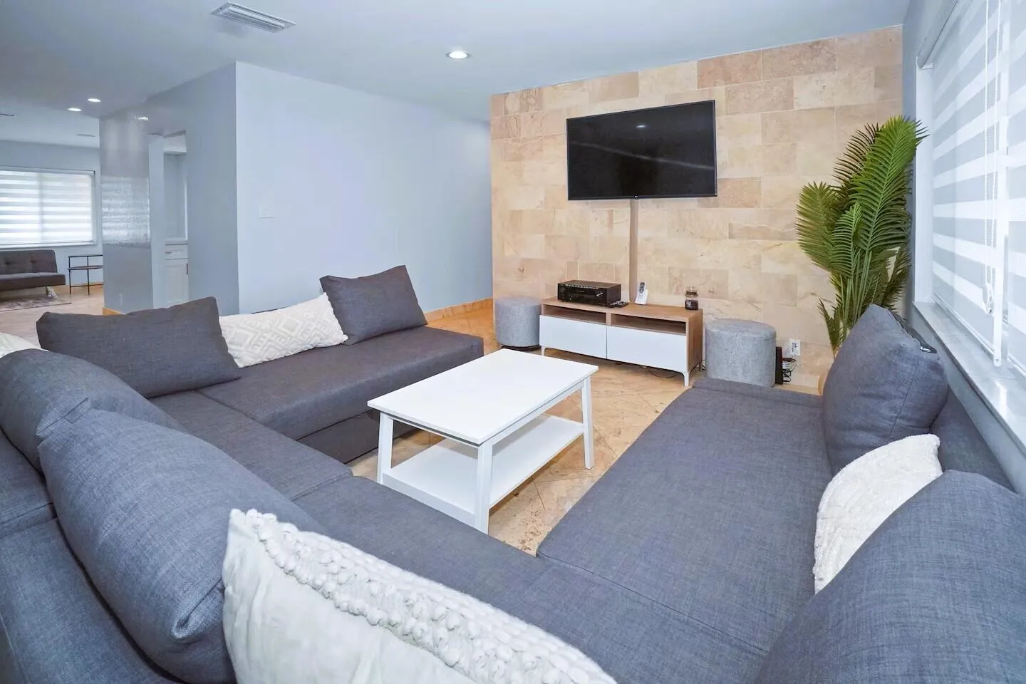 Living space featuring a stone veneer accent wall and tile flooring