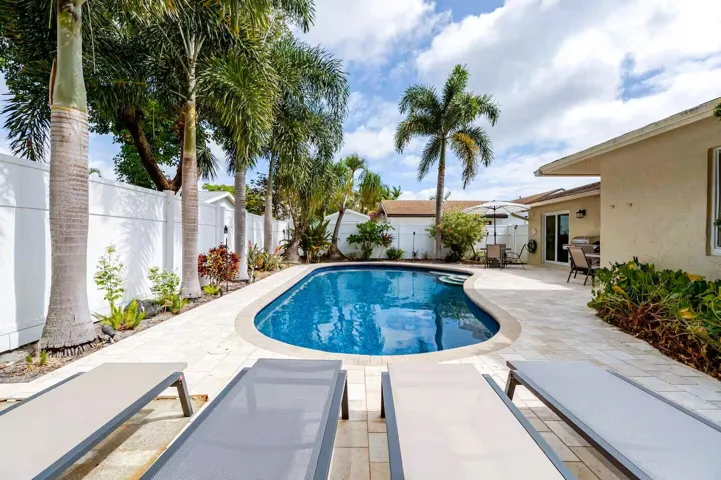 Freeform swimming pool surrounded by a paver patio