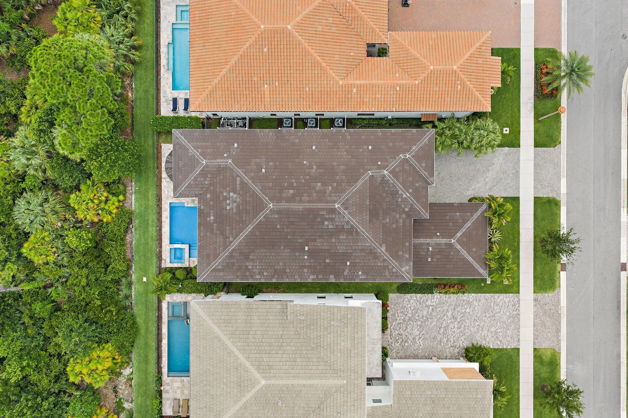 Overhead aerial view of the property showing roof layout, pool, and driveway