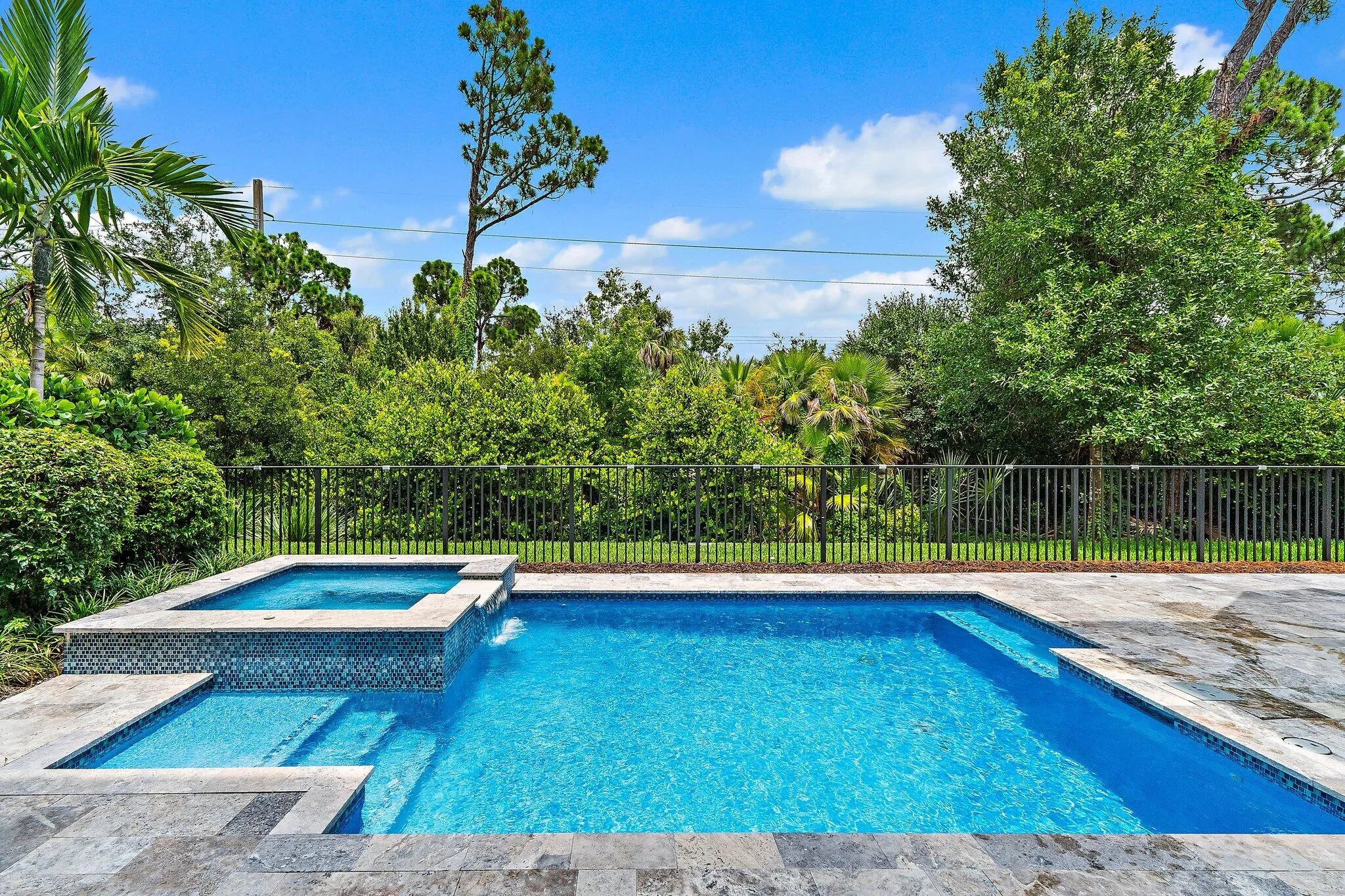 Backyard pool and spa with paver deck and fenced yard