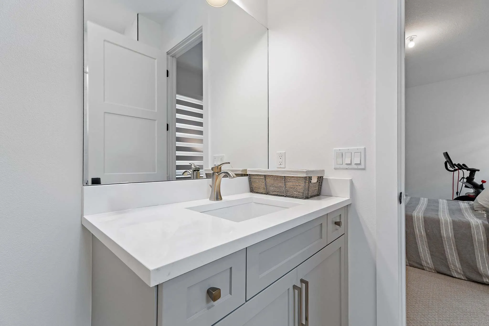 Bathroom with gray vanity, marble countertop, and mirror