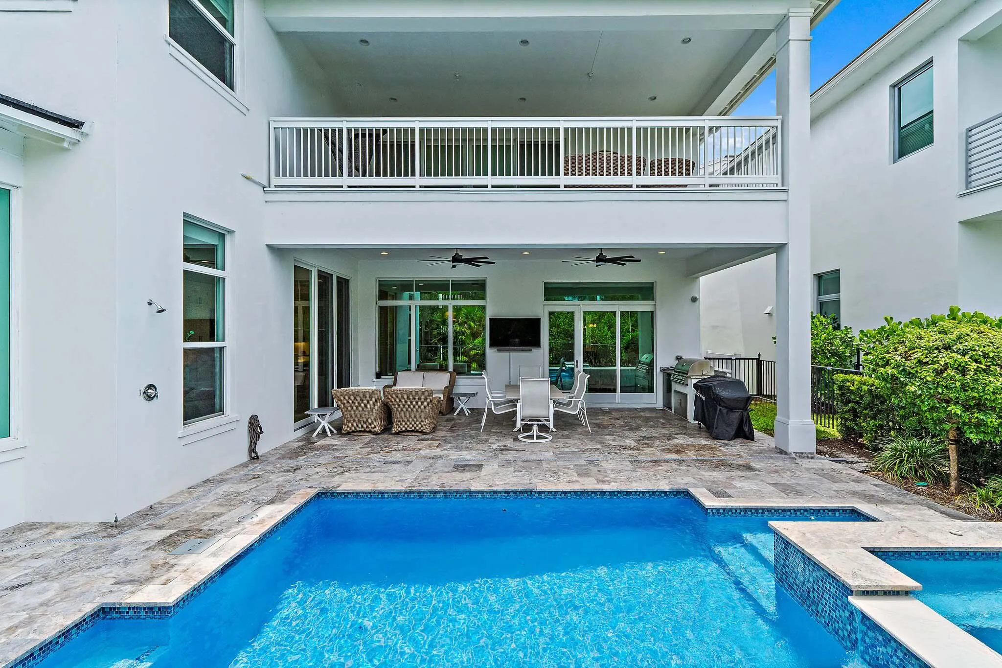 Rear exterior with pool, covered patio, and second-story balcony