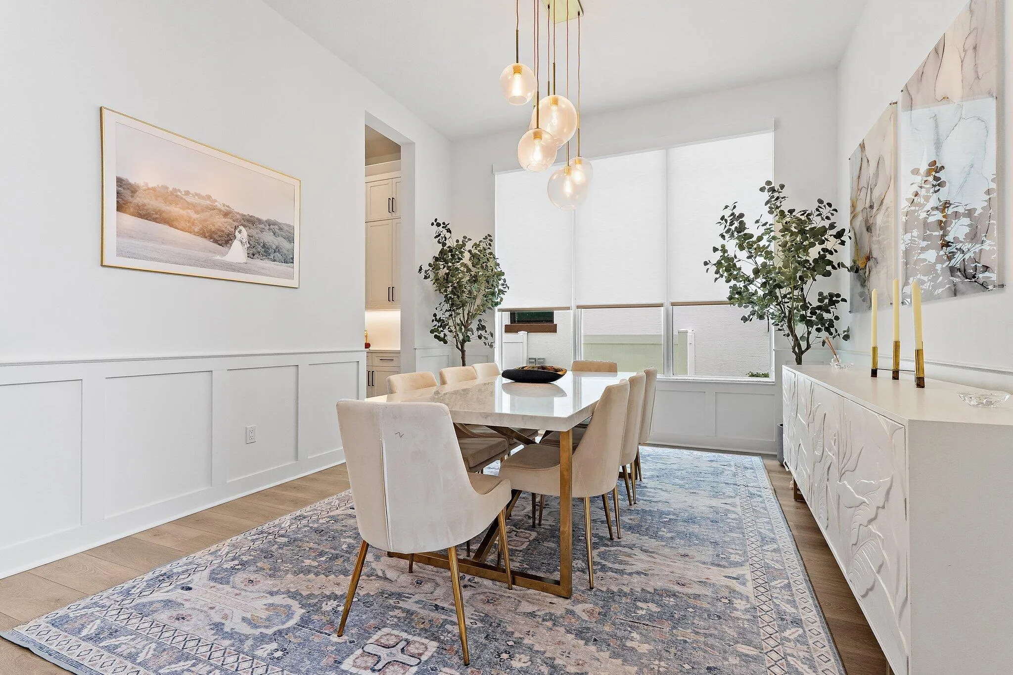 Dining area with table, upholstered chairs, and modern pendant lighting