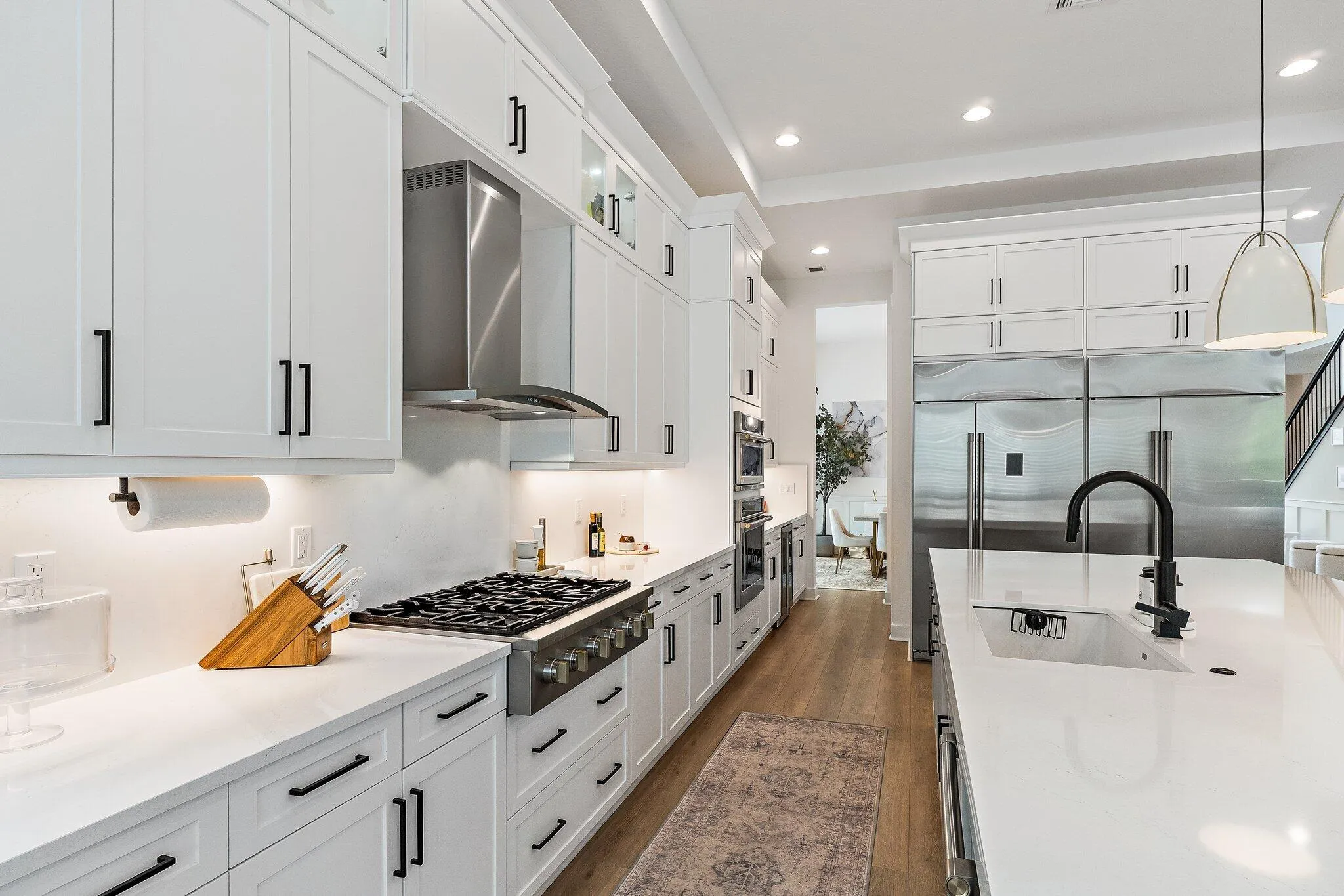 Kitchen with marble backsplash, professional-style range hood, and farmhouse sink