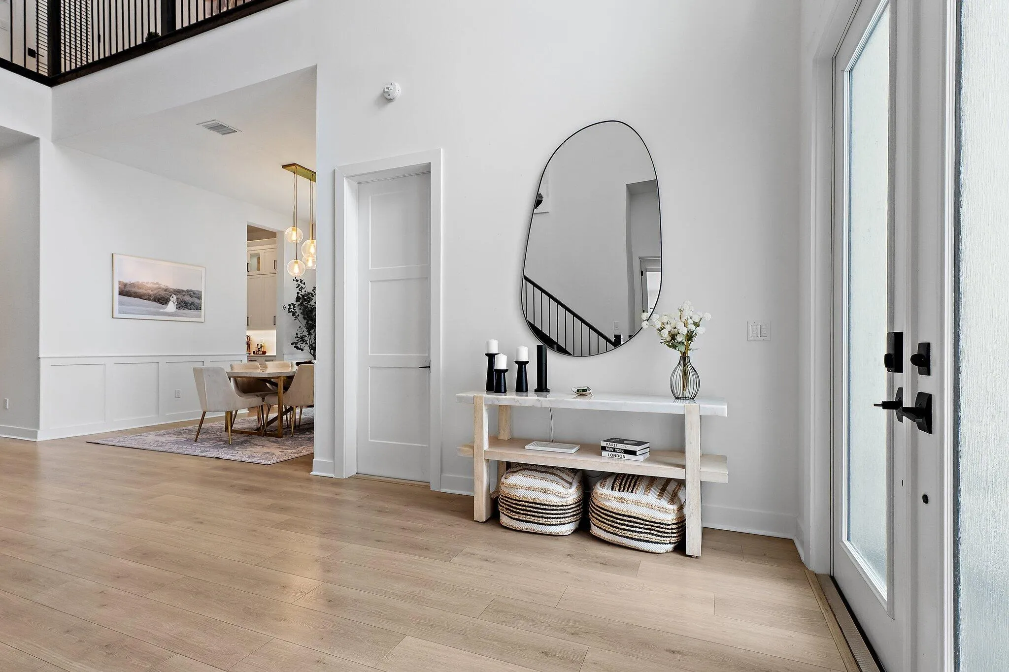 Entry hallway with console table, mirror, and staircase in background