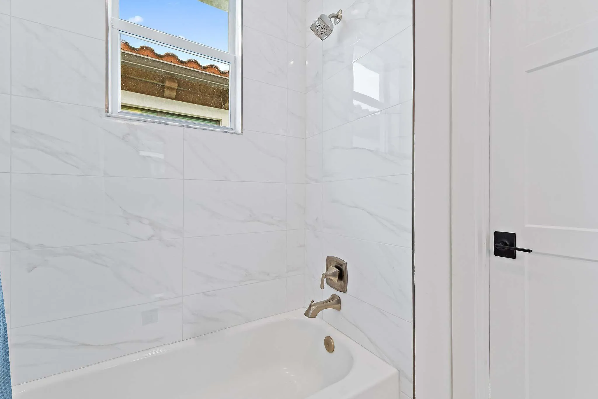Bathroom with tub and marble tile surround