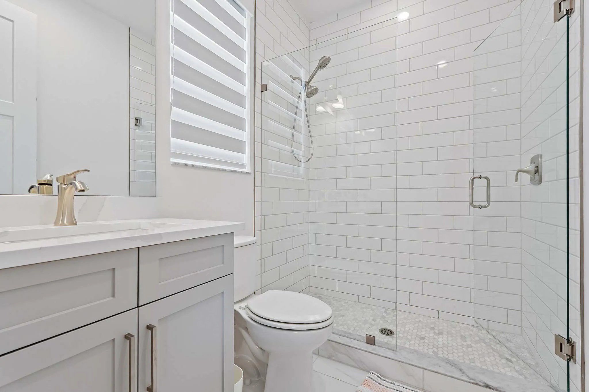 Bathroom with subway tile shower and gray vanity