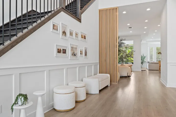 Hallway with staircase, gallery wall, and decorative garden stools