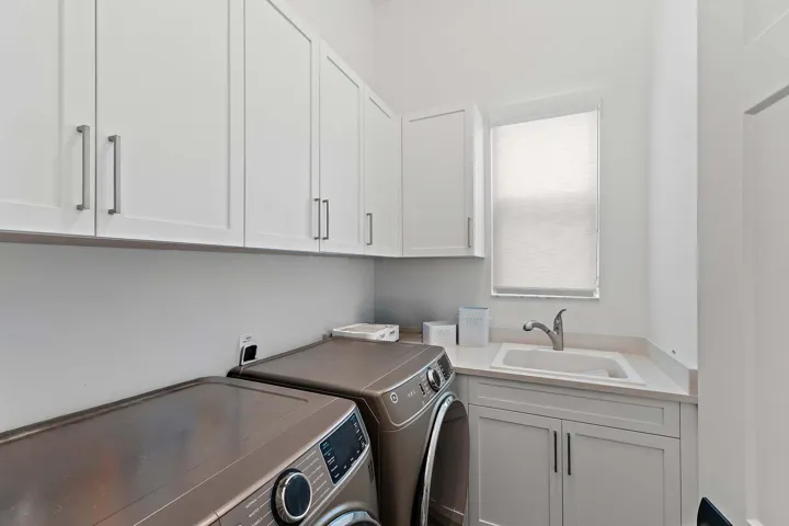 Laundry room with washer, dryer, and farmhouse sink