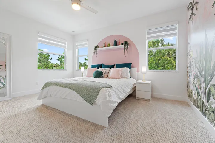 Bedroom with arched accent wall and windows overlooking trees