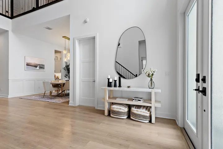 Entry hallway with console table, mirror, and staircase in background