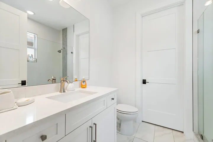 Bathroom with white cabinetry, single vanity, and tile flooring
