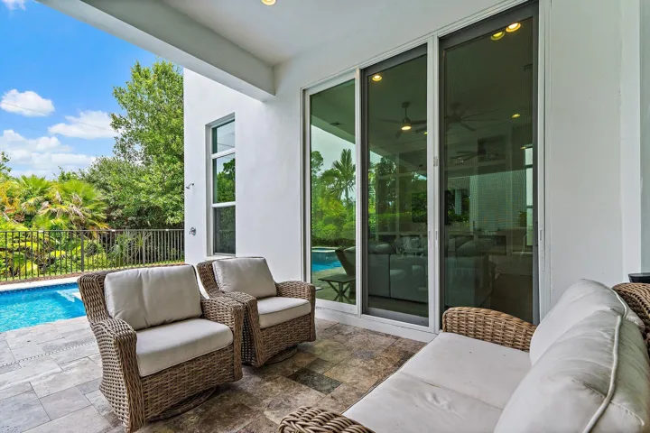 Outdoor sitting nook with wicker furniture and pool view