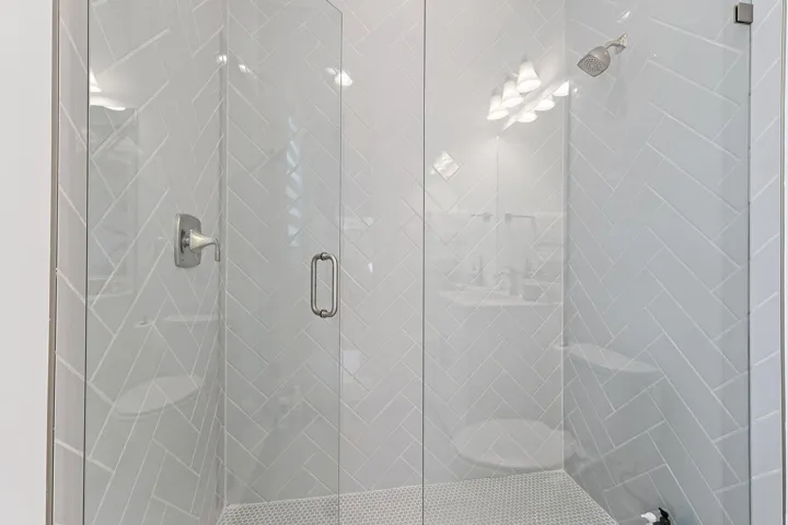 Glass-enclosed shower with tile surround
